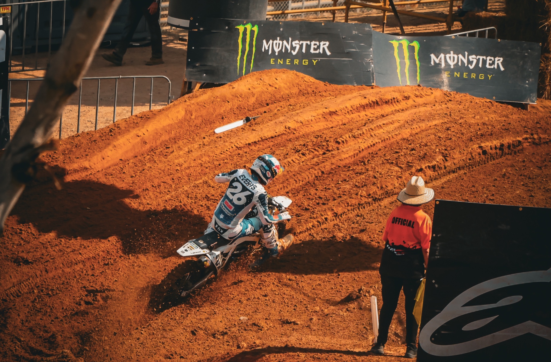 Motocross rider carving through a deep dirt corner during competition.