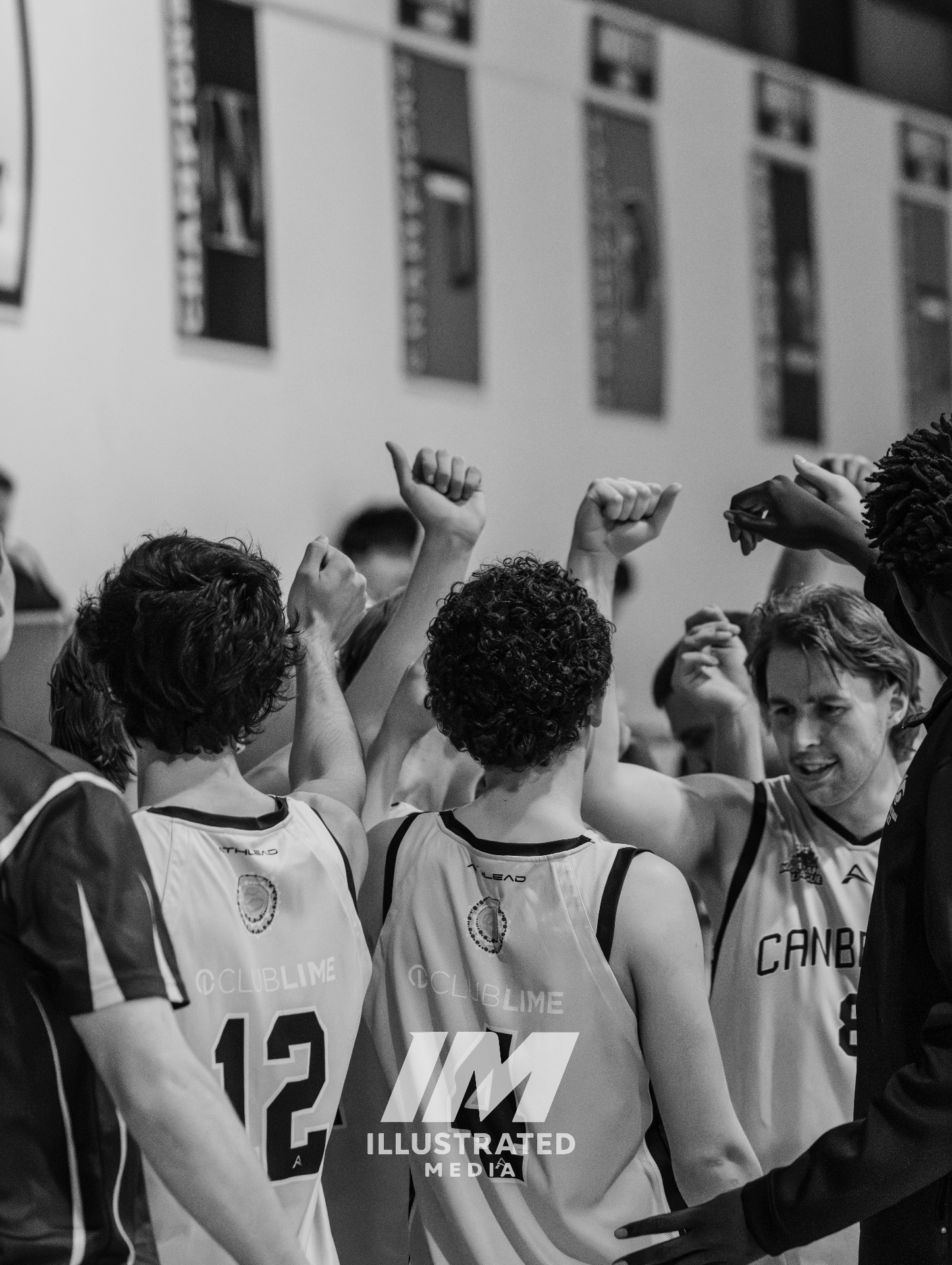 Basketball team huddle captured in black and white before returning to play.